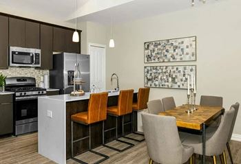 A kitchen and dining room with a table and chairs